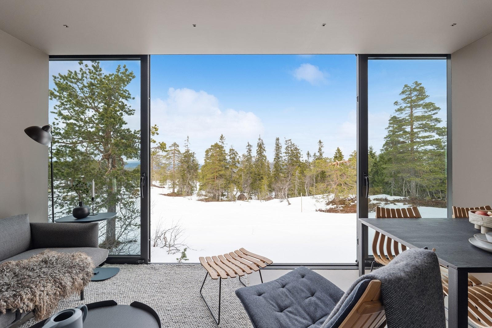 Det er skyvedører i stuen som kan åpnes mot nature. Skiløyper rett utenfor. Galleribilde