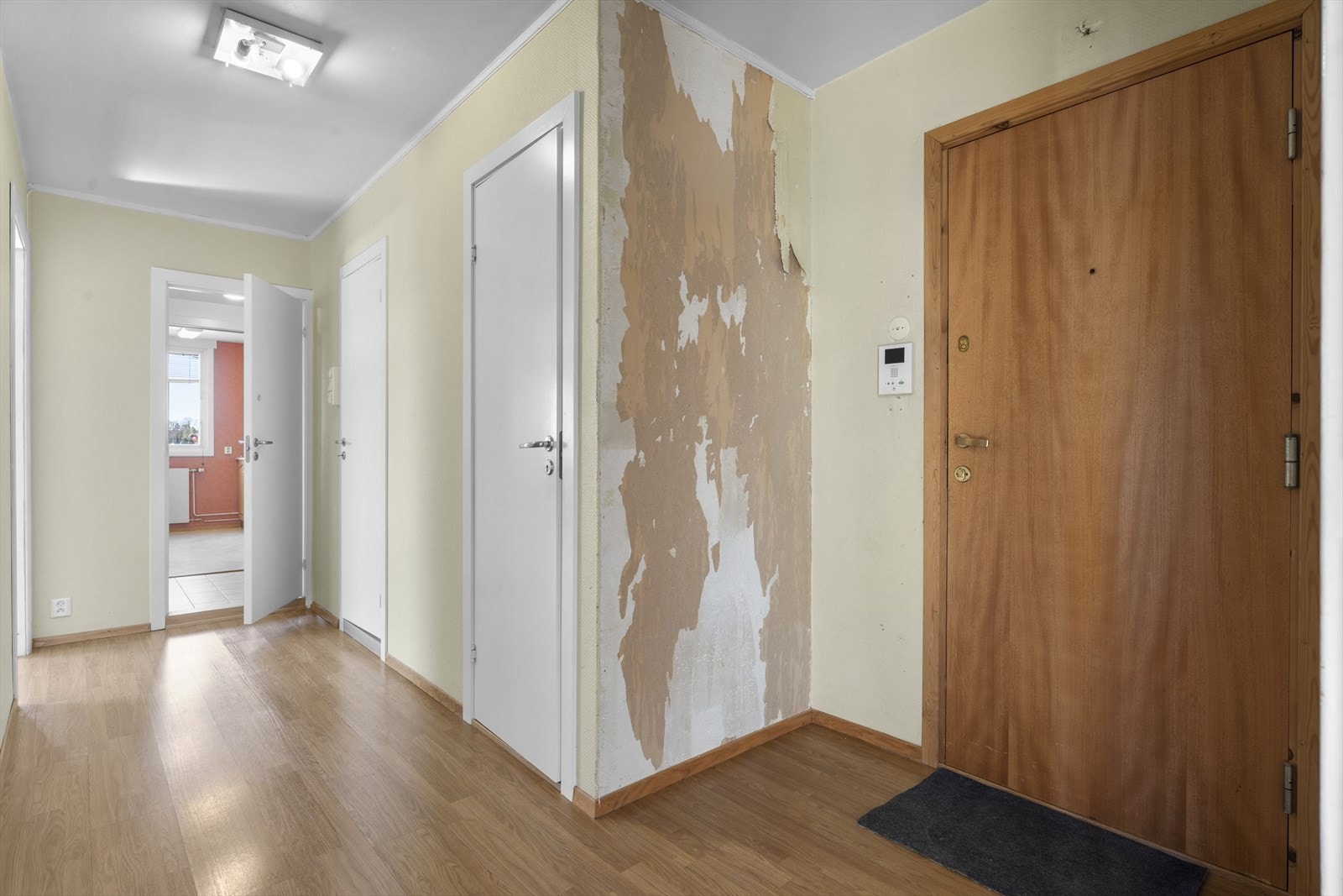 Entréen har laminatgulv og malte vegger, med tilgang til flere rom i boligen. Galleribilde