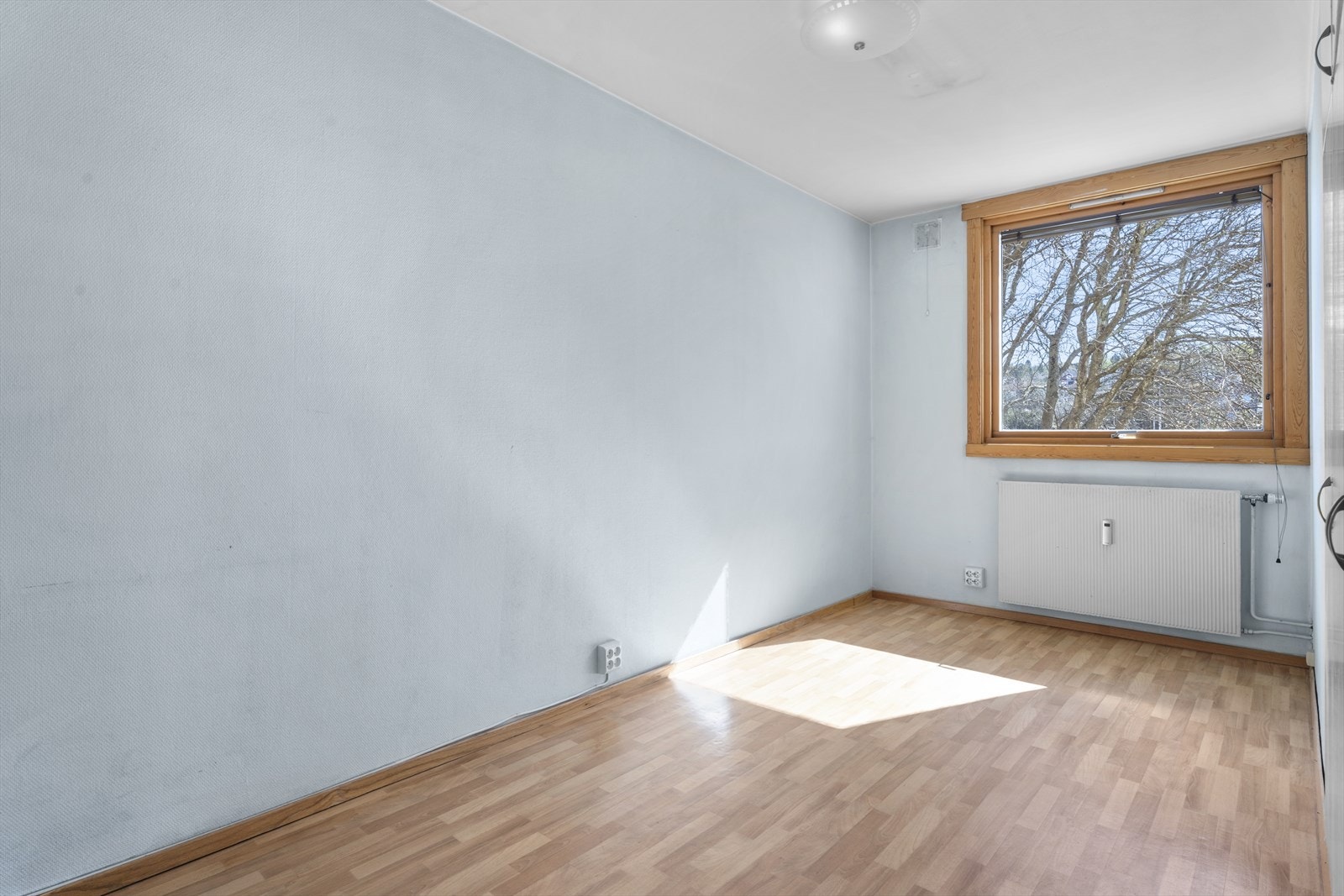 Rommet har malte veggflater og parkettgulv som gir en enkel og funksjonell innredning. Galleribilde