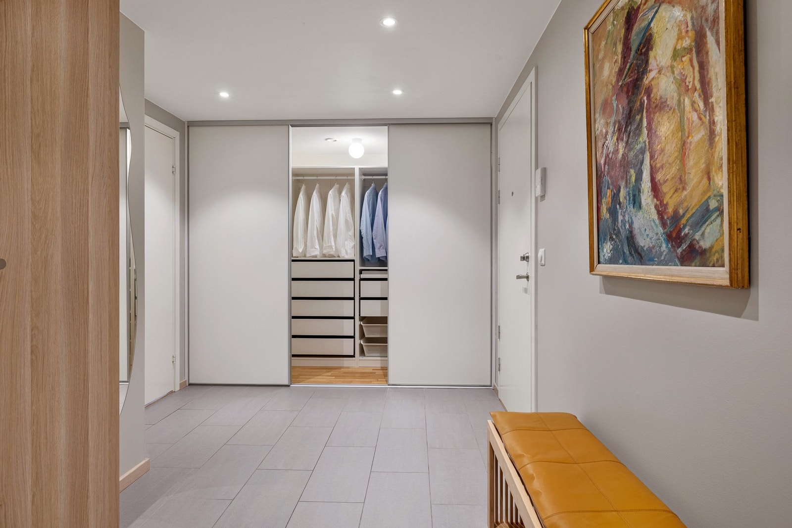 Langs hele den ene veggen er det en walk-in closet garderobe med skyvedører. Galleribilde