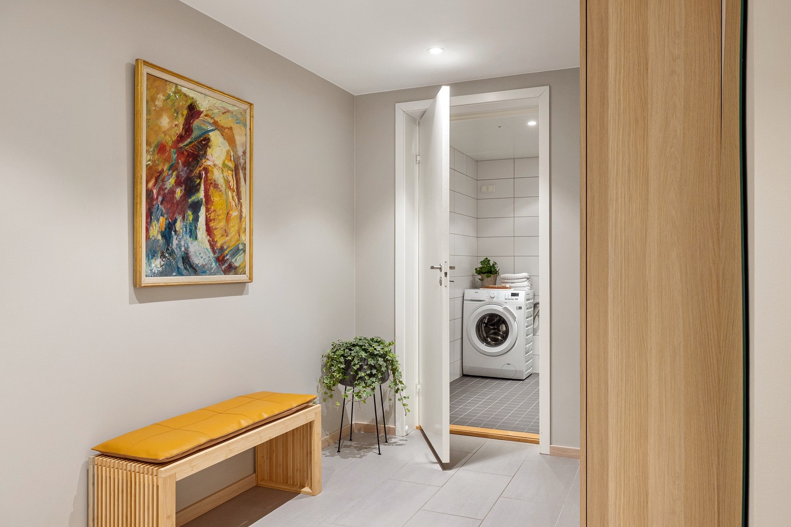 Entréen har flislagt gulv, glatte malte overflater, skjult elektrisk anlegg og downlights i himlingen. Galleribilde