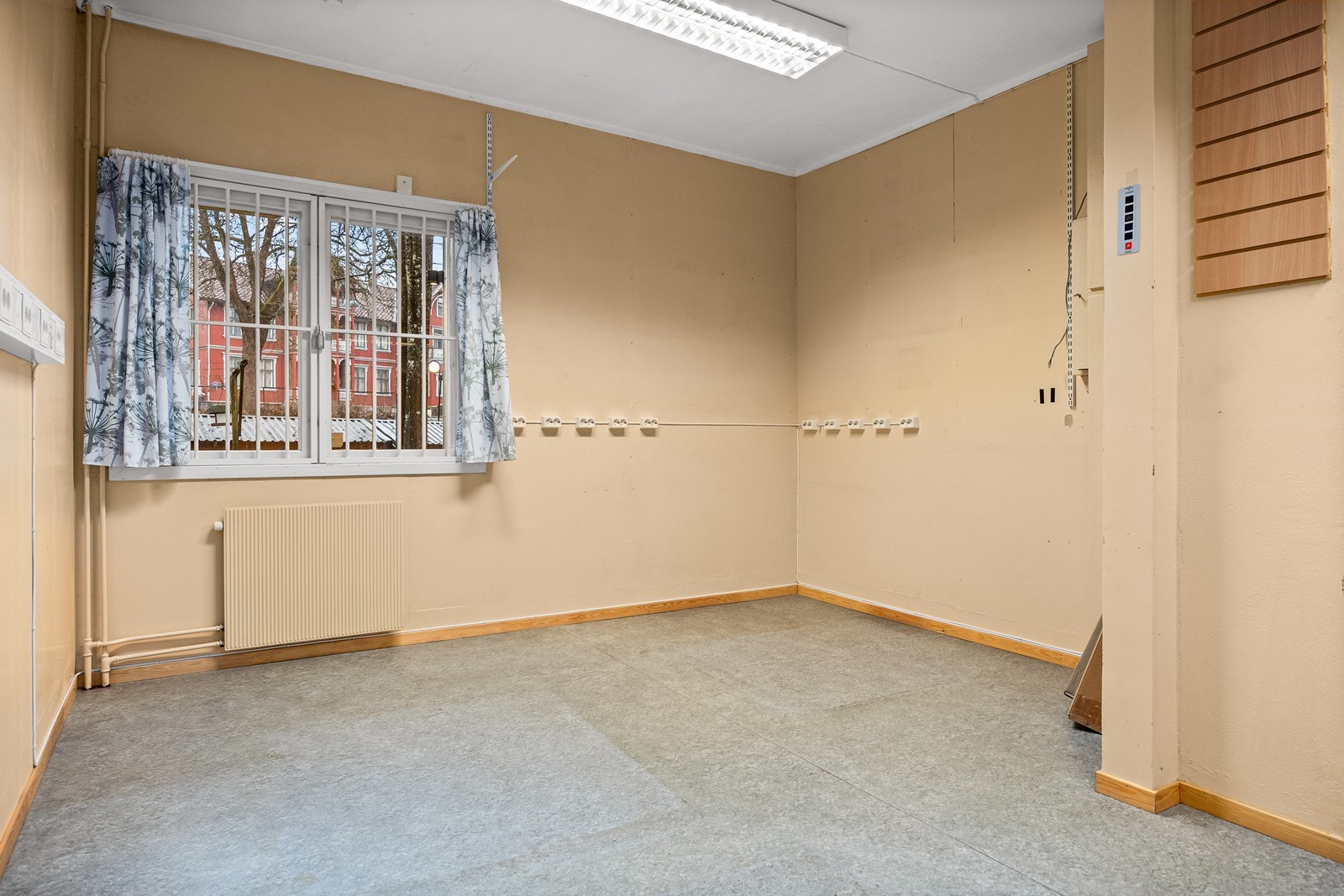 Næringslokalet har gulvbelegg og lysmalte vegger, som gir et praktisk utgangspunkt for videre bruk. Galleribilde