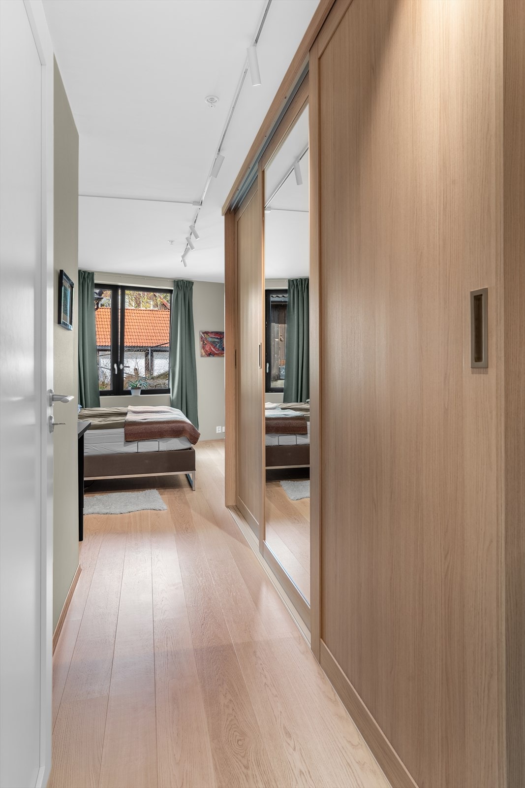 Hovedsoverommet er innredet med en stor skyvedørsgarderobe Galleribilde