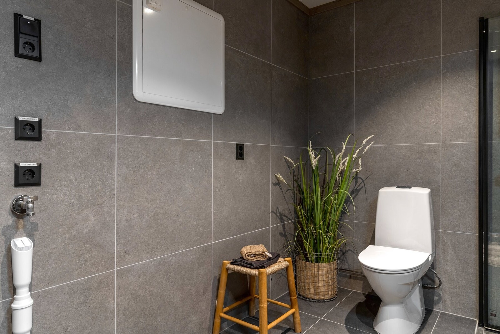 Badet er innredet med toalett, dusj, servant med innredning og opplegg for vaskemaskin. Galleribilde