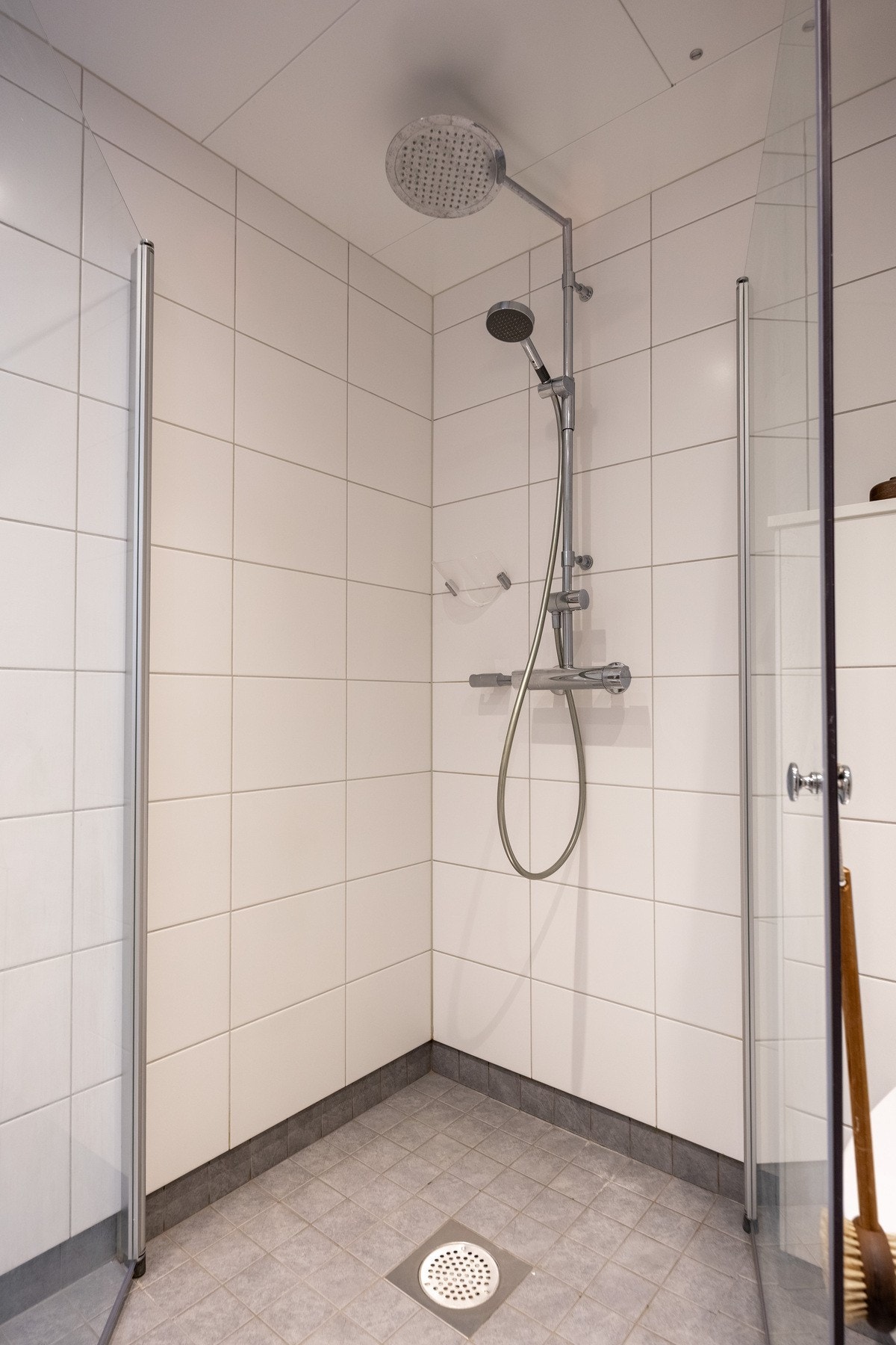 Romslig dusjhjørne med skyvedører i glass. Galleribilde