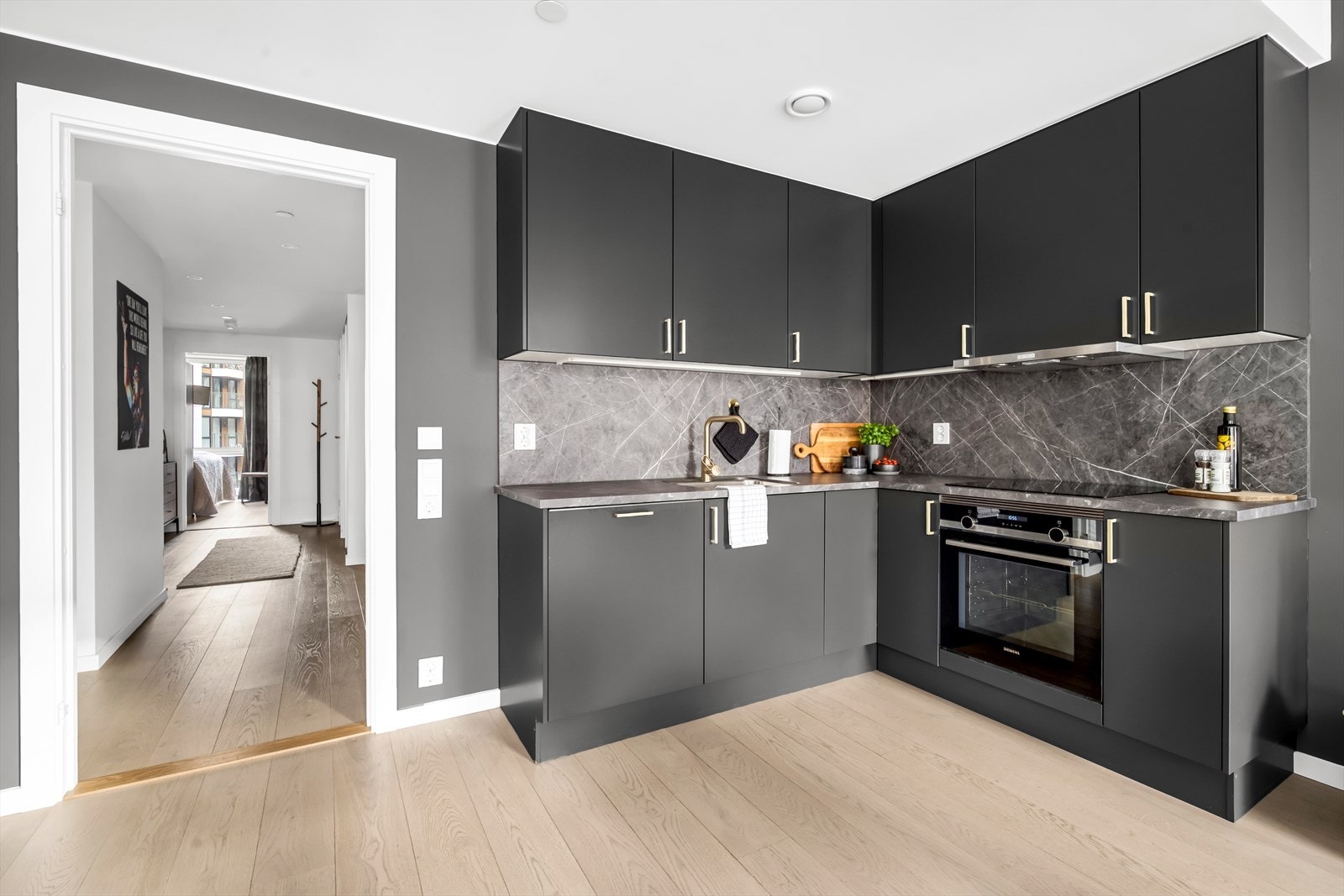 Kjøkkenet er designet med fokus på funksjonalitet, med godt med benke- og skapplass. Det har en stilren innredning med glatte fronter og benkeplate av laminat. Galleribilde
