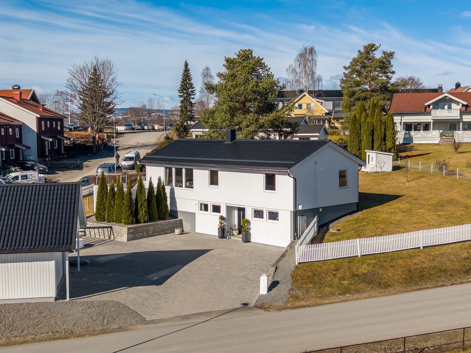 Tomten er svakt skrånende og pent opparbeidet med brosteinsbelagt gårdsplass og hageanlegg. Galleribilde