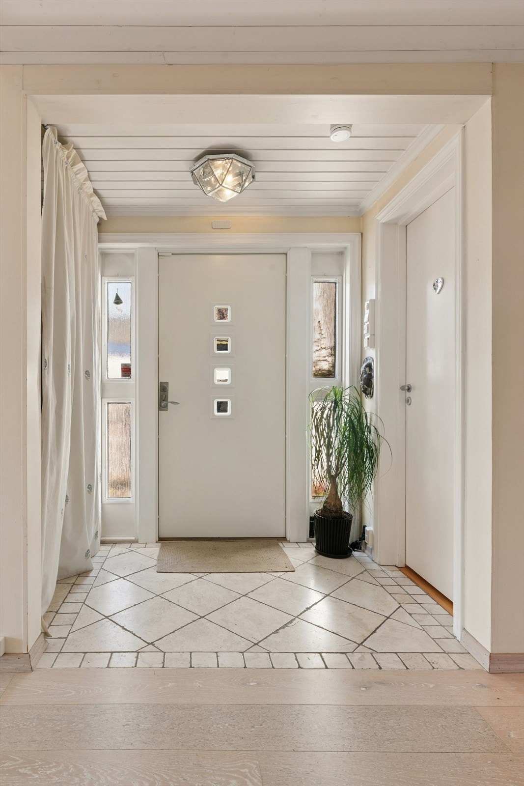 Velkommen inn! Romslig, påbygd entré med fliser og varmekabler på gulvet. Garderobeløsning til venstre og inn til dusjbad og vaskerom til høyre. Galleribilde