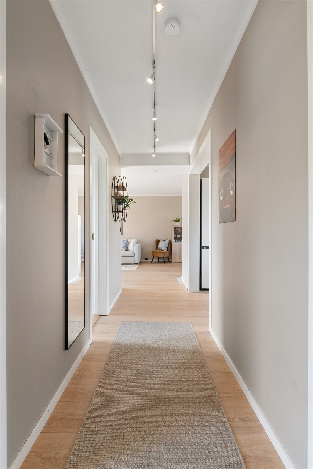 Fra entréen leder en gang deg videre inn til stuen og de øvrige rommene i boligen. Galleribilde