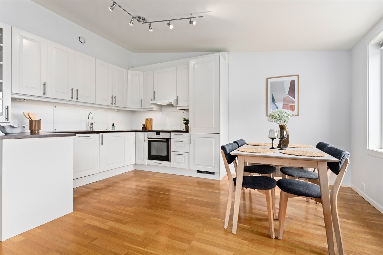 Kjøkenet har innreiing frå byggjeåret med profilerte og lakkerte MDF-frontar og benkeplate av laminat med treimitasjon. Galleribilde