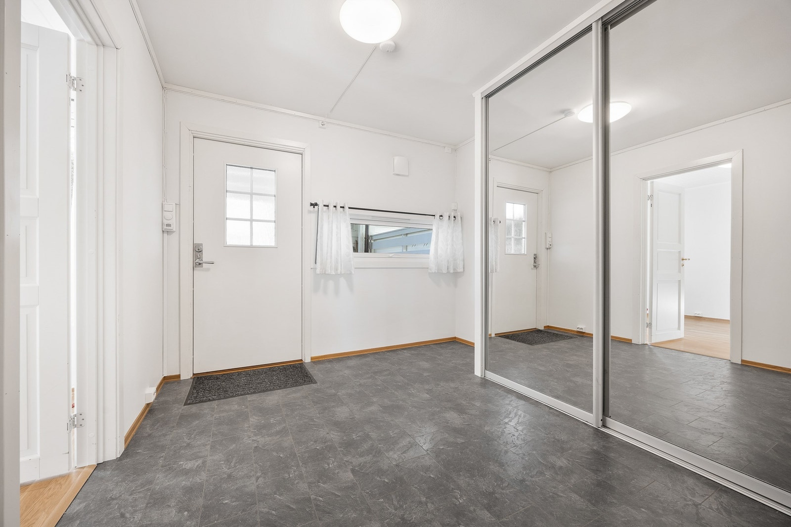 Romslig entré med en stor skyvedørsgarderobe for effektiv oppbevaring av yttertøy og sko. Galleribilde