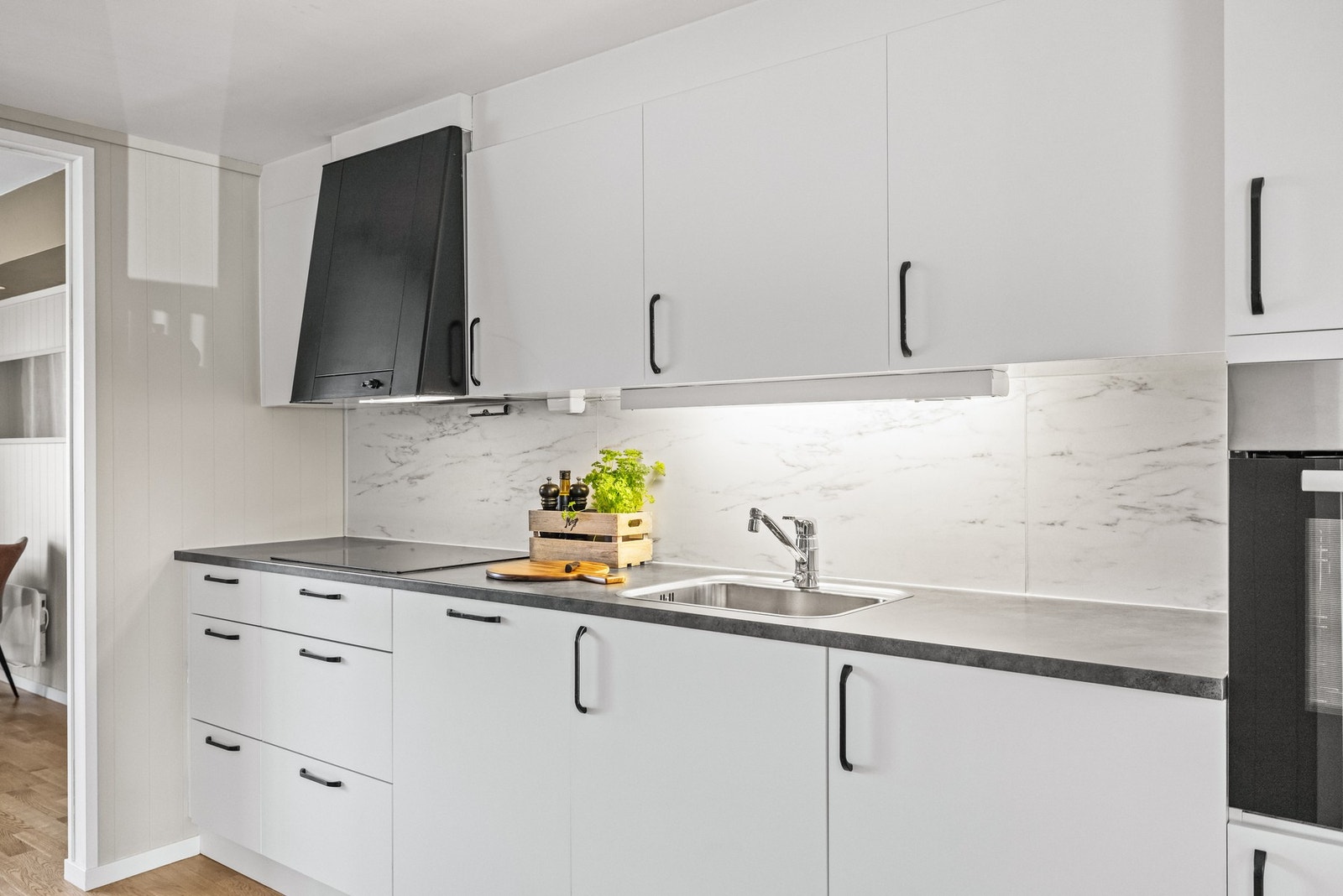 Innredningen har hvite, slette fronter og laminert benkeplate, som gir et tidløst og rent uttrykk. Galleribilde