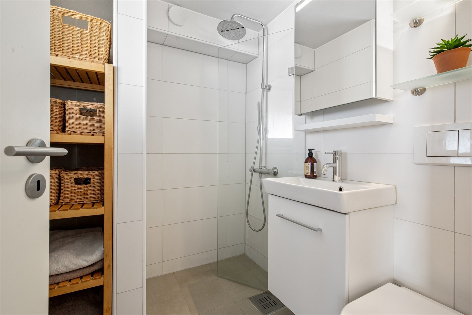 Badet er fra 2012 og har lyse fliser på gulv og vegger. Galleribilde