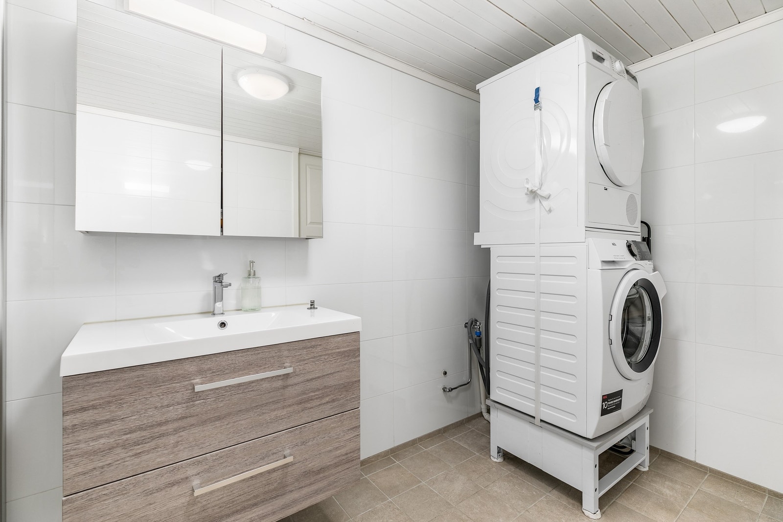Kjellerbadet fungerer i i tillegg som vaskerom. Gulv og vegger er som på badet i andre etasje utført med fliser, gulvet også med varme. Galleribilde