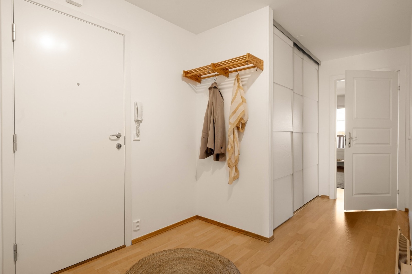 Entré med innebygd skyvedørsgarderobe med gode oppbevaringsmuligheter. Callinganlegg er montert på veggen ved inngangsdøren. Galleribilde