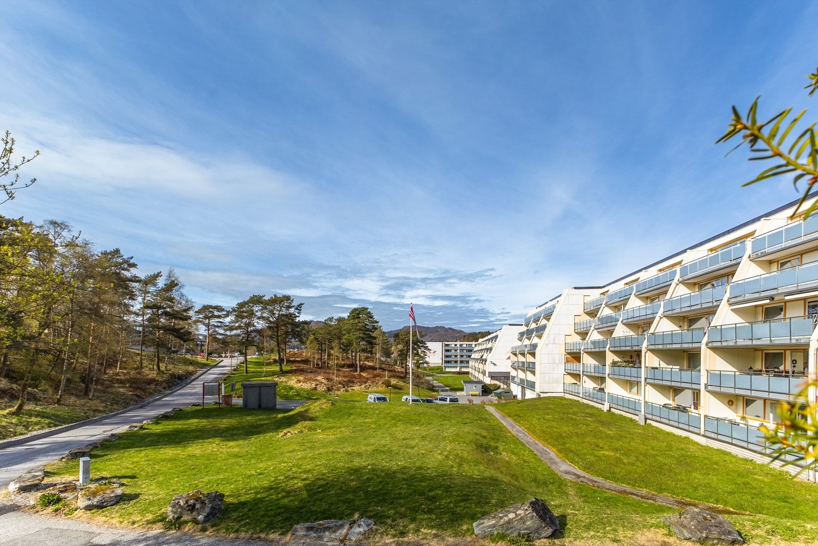 Borettslagets tomt er pent opparbeidet med plener, beplantning, gangveier og parkeringsplasser Galleribilde
