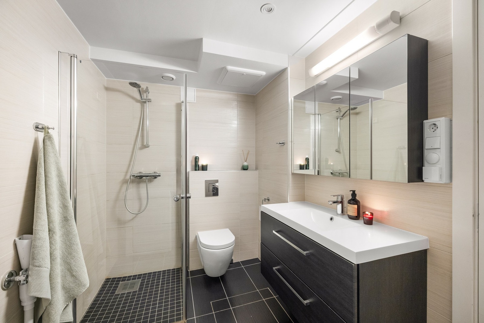 Badet i underetasjen har flislagte gulv og vegger, veggmontert toalett og elektriske varmekabler. Galleribilde