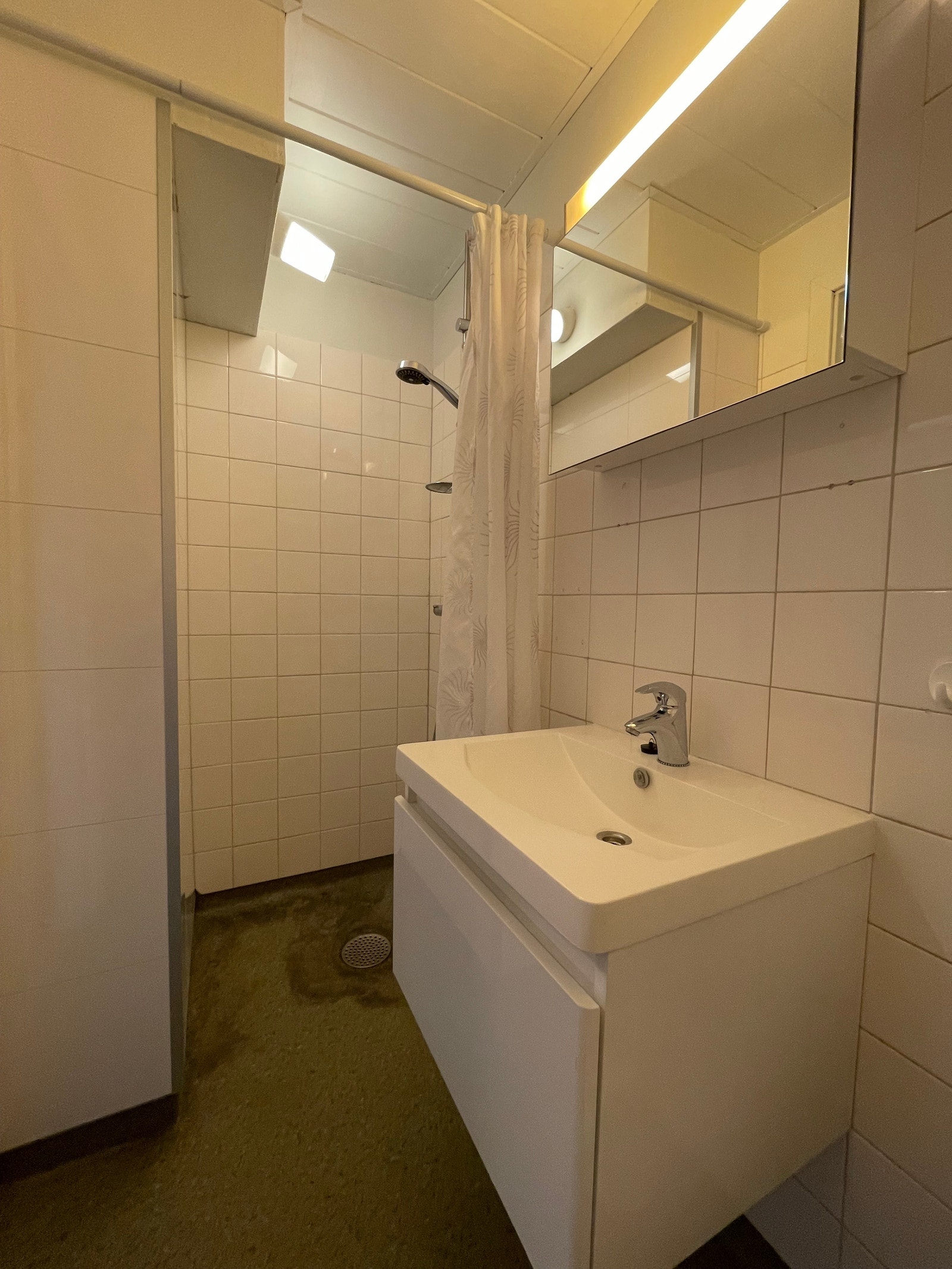Bad med dusjhjørne og servant med underskap. Galleribilde