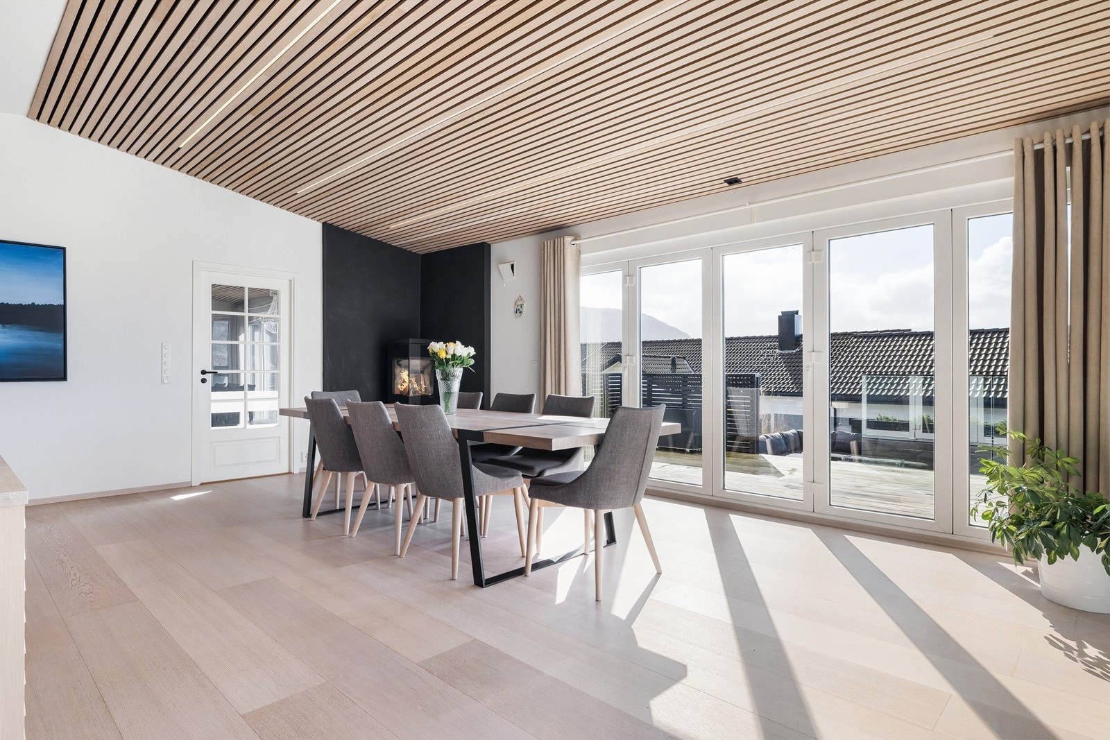 Store foldedører langs hele veggen gir rikelig med lys og kan åpne helt opp mot terrassen. Galleribilde