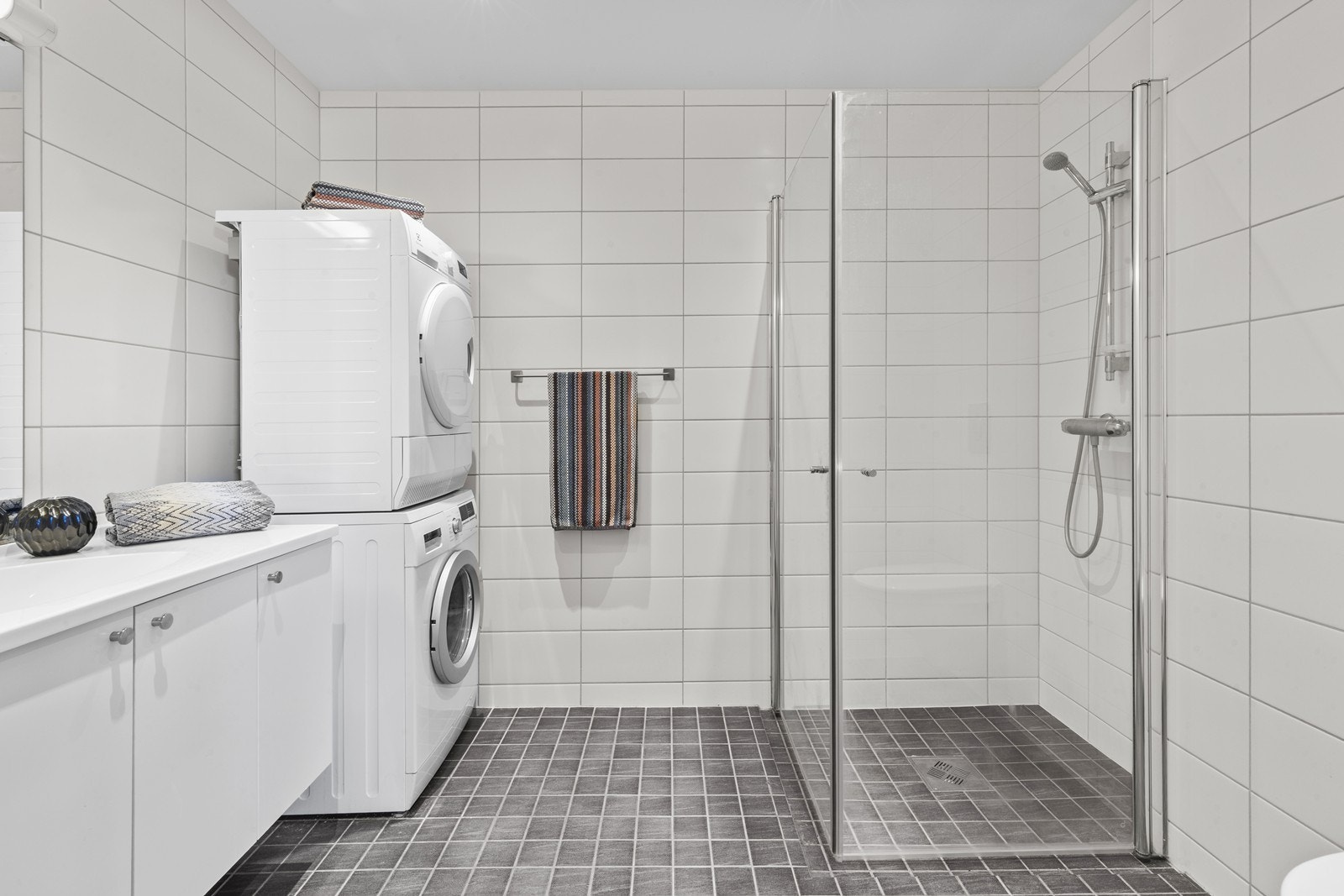 Badet har dusjhjørne med glassdører og vannbåren varme i det flislagte gulvet. Galleribilde