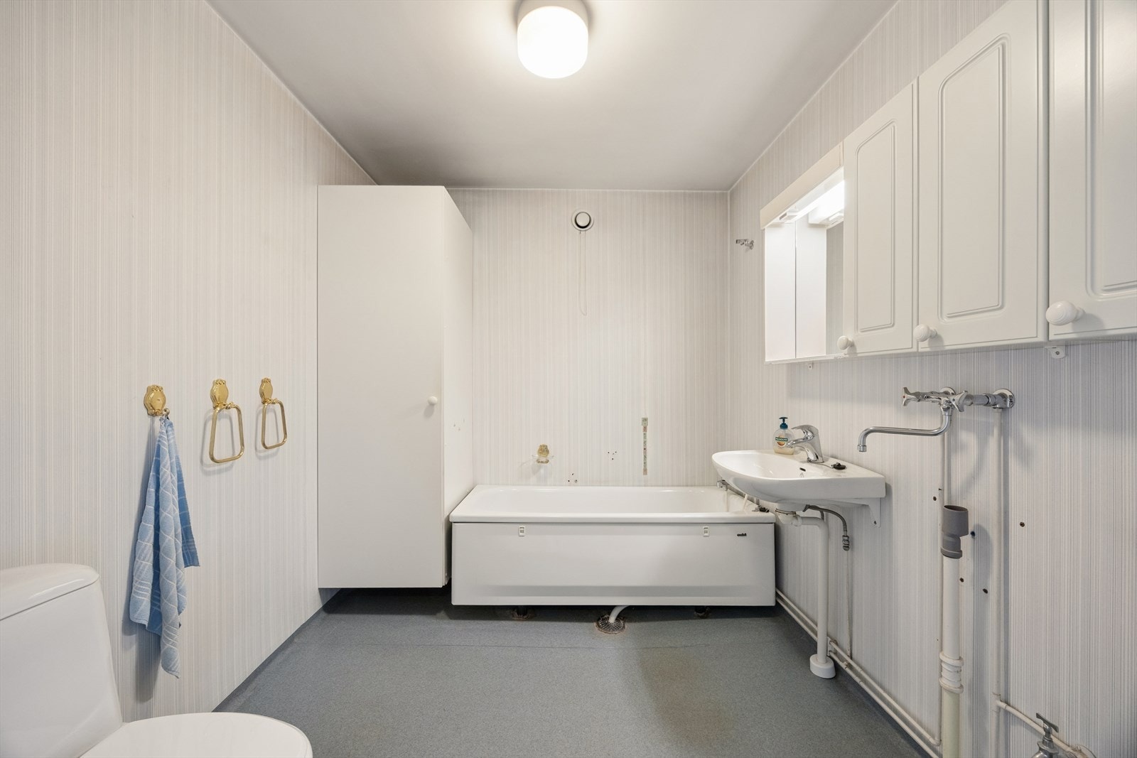 Romslig bad med adkomst fra entré. Badet har flislagte vegger og gulv med belegg Galleribilde