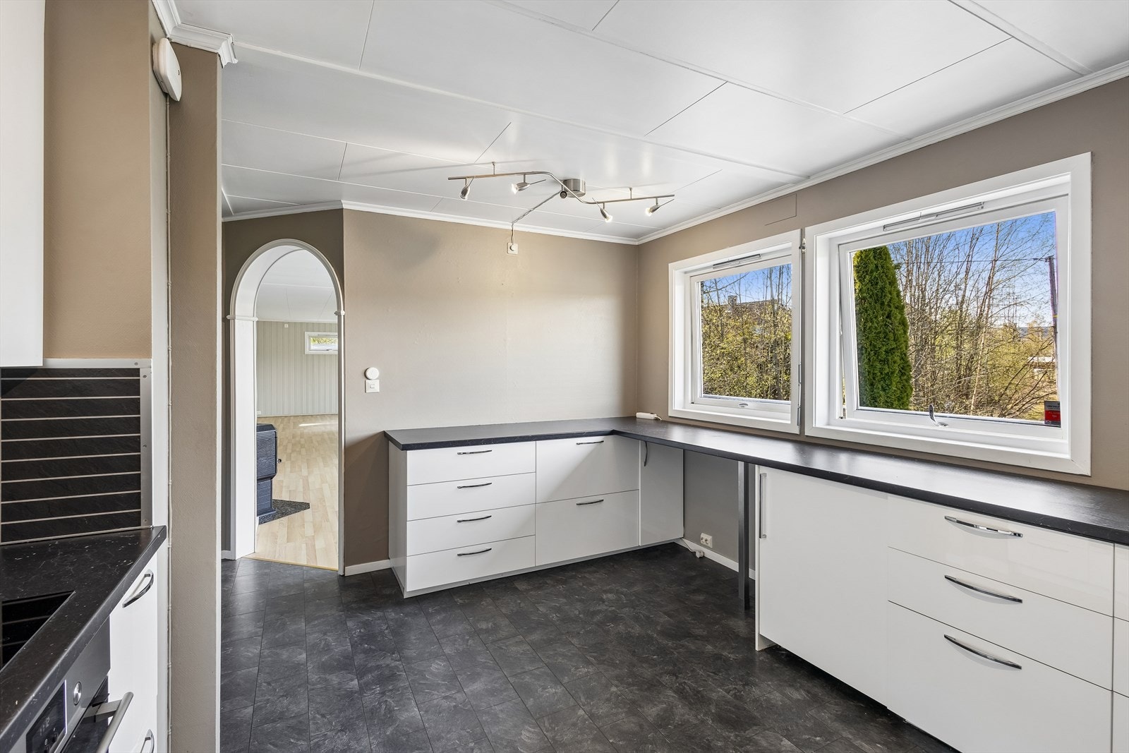 Kjøkkeninnredning med god benkeplass og en åpen løsning mot spiseplassen skaper et sosialt og funksjonelt rom. Galleribilde