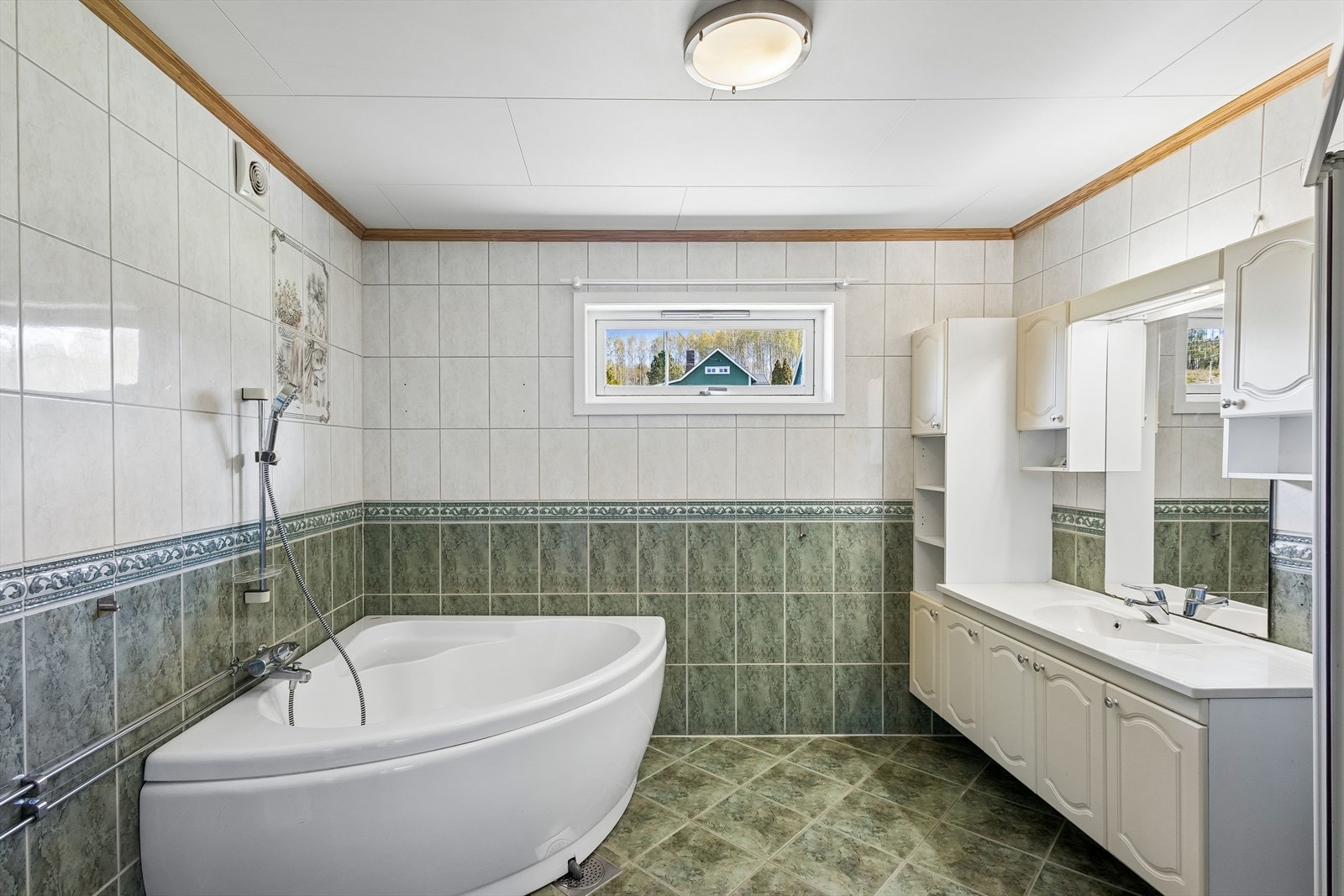 Hovedbadet fra 1998 er helfliset og utstyrt med både badekar og dusjnisje. Galleribilde