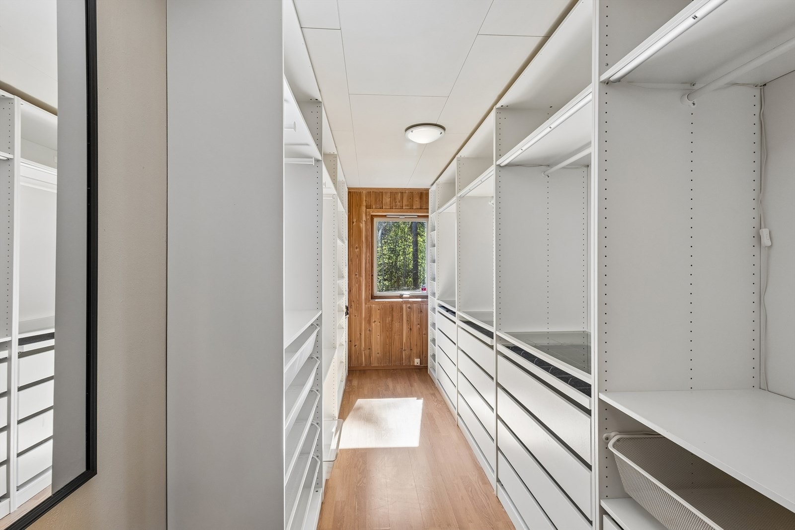 Et av soverommene er innredet som et praktisk walk-in-closet med rikelig lagringsplass. Galleribilde