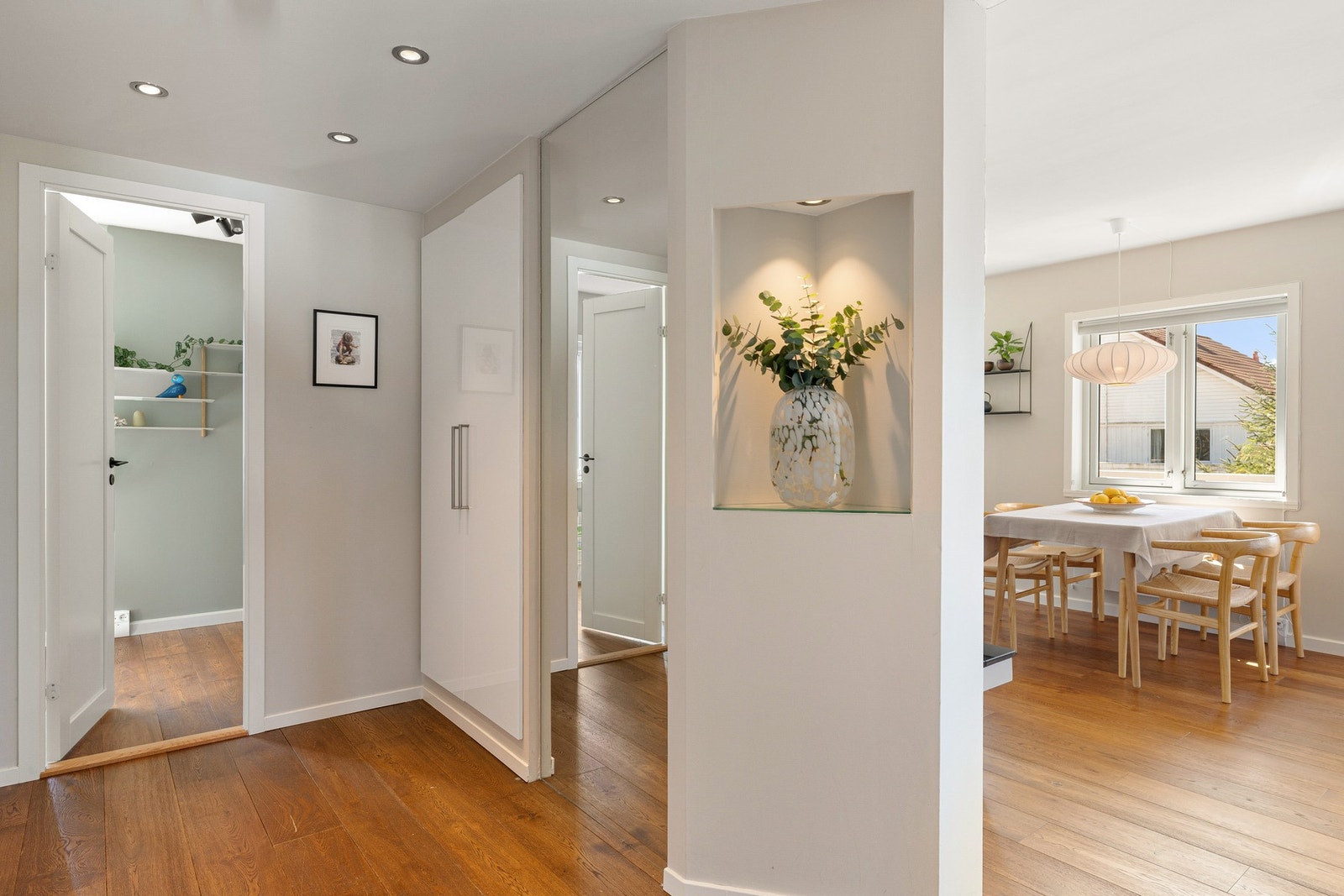 Entréen gir et godt førsteinntrykk av boligen med parkettgulv, lysmalte flater og downlights i soner i tak. Dette er gjennomgående for leiligheten. Galleribilde
