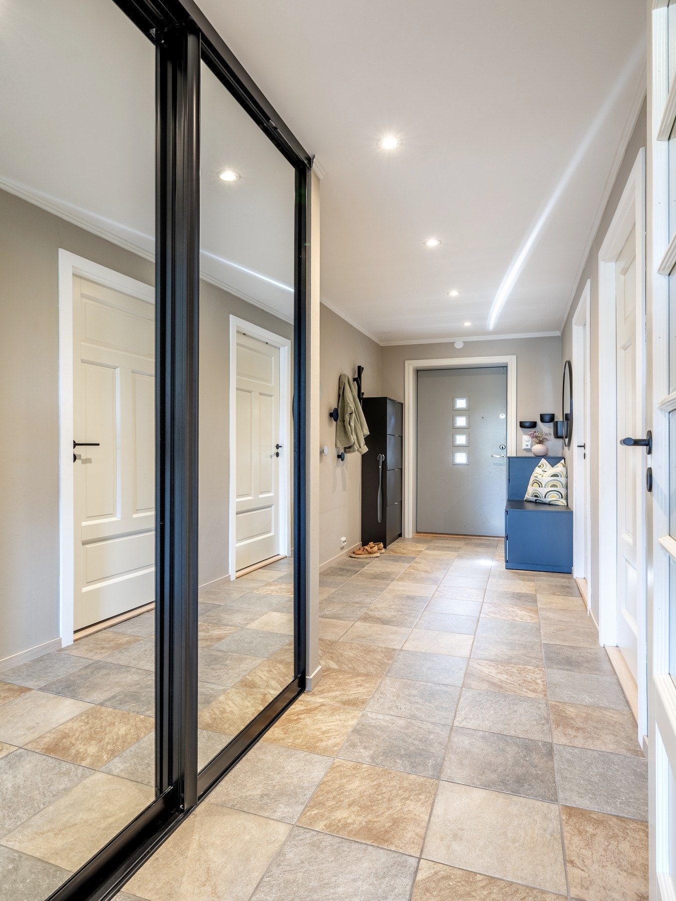 Langs med den ene veggen er det en praktisk skyvedørsgarderobe med plass til yttertøy, sko og annet utstyr. Galleribilde