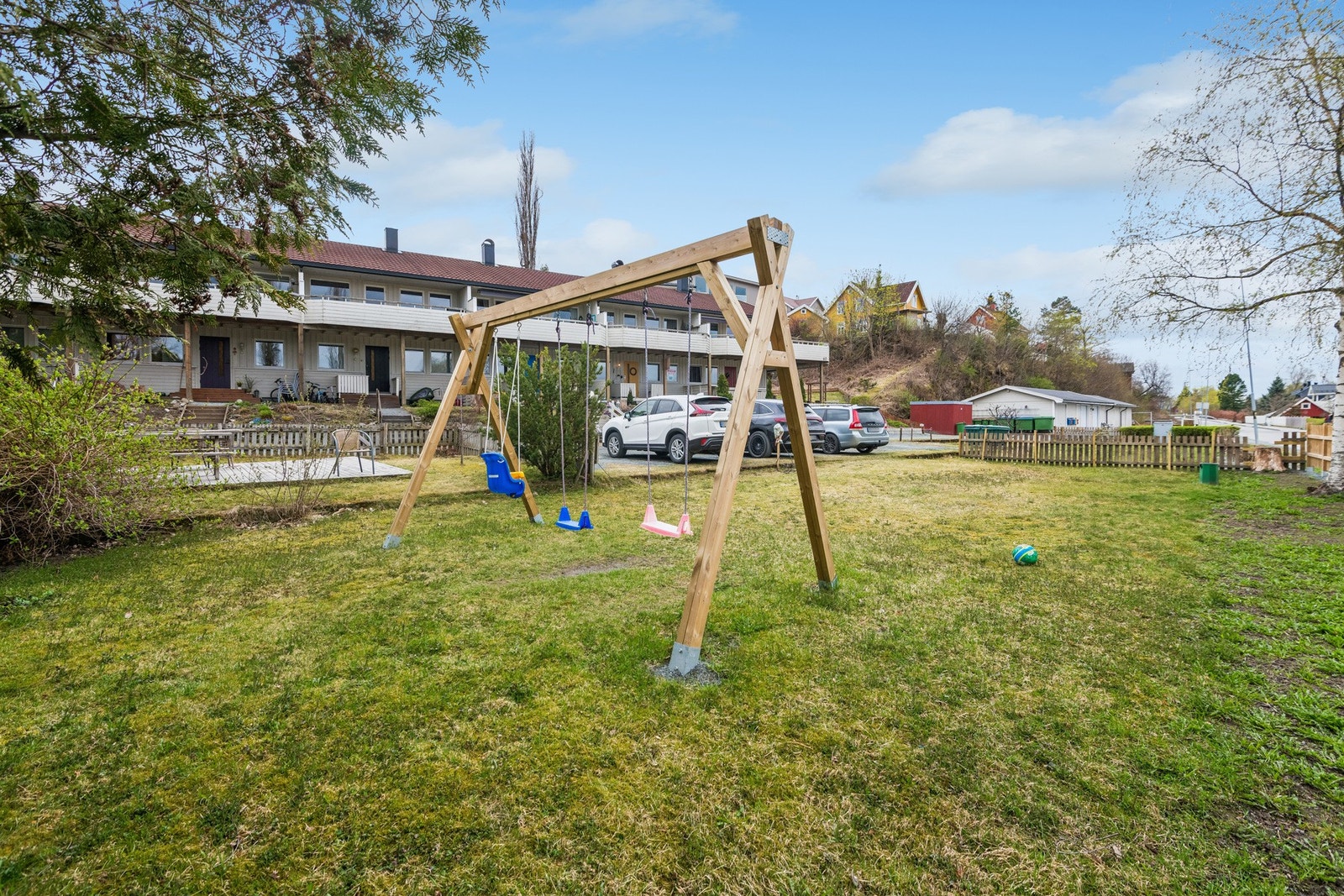 Utendørs har man enkel tilgang til et pent opparbeidet fellesområde med huskestativ, gressplen og en platting med utemøbler. Galleribilde