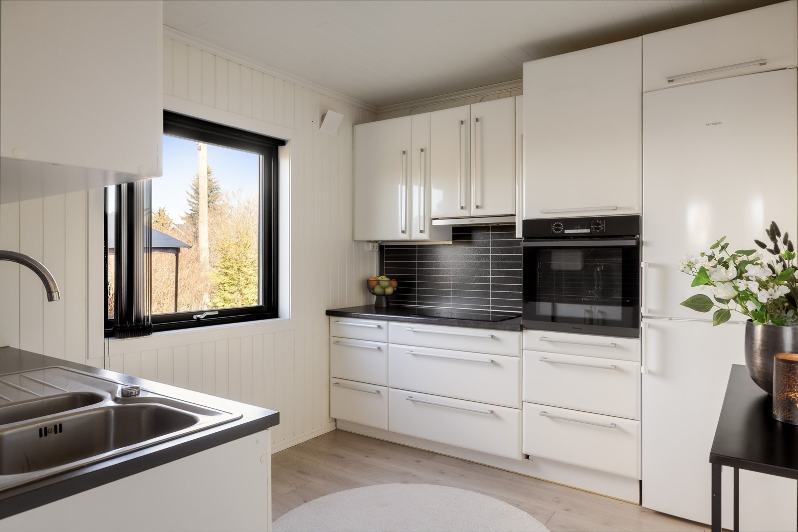 Kjøkkenet har glatte fronter og benkeplate i laminat med nedfelt oppvaskkum i rustfritt stål med liten skyllekum. Galleribilde
