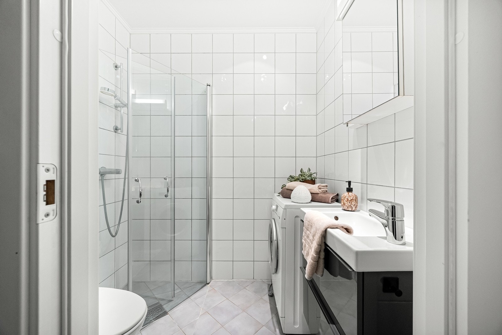 Flislagt baderom i tidløst design fra 2009 med gulvvarme og opplegg for vaskemaskin. Galleribilde
