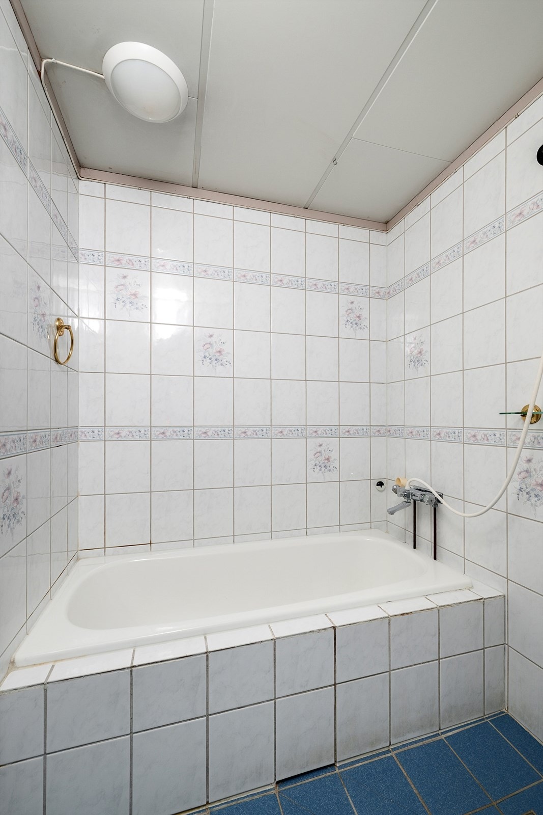 Badet er innredet med et innfliset badekar. Galleribilde