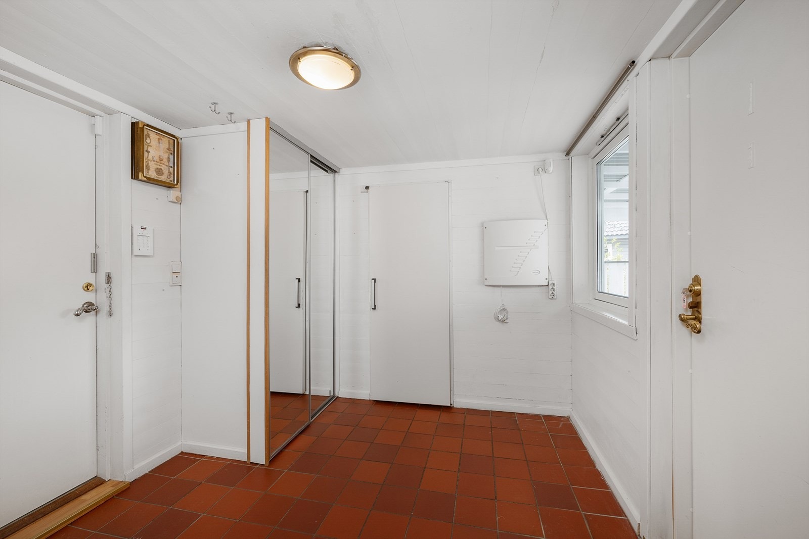 Entréen har flislagt gulv med varmekabler og plass til garderobeløsning. Galleribilde
