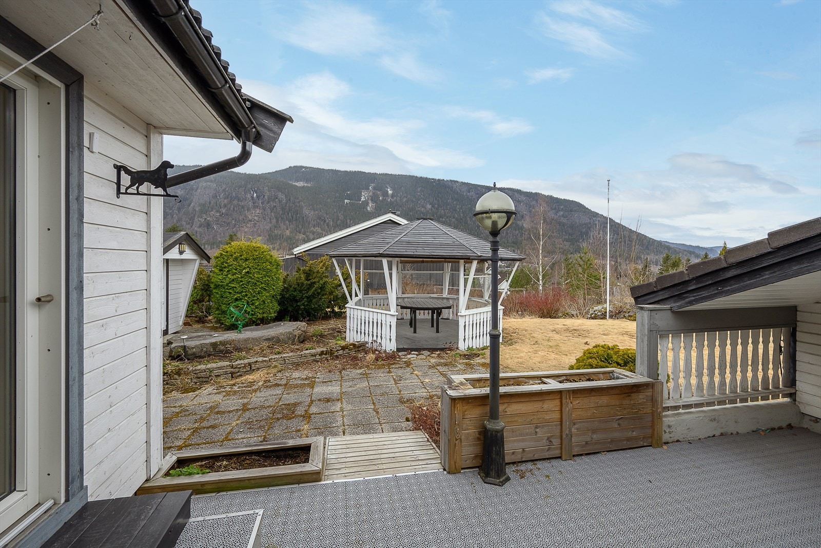 Uteområdet er pent opparbeidet med hellelagt uteplass, plen og en frittstående paviljong. Galleribilde