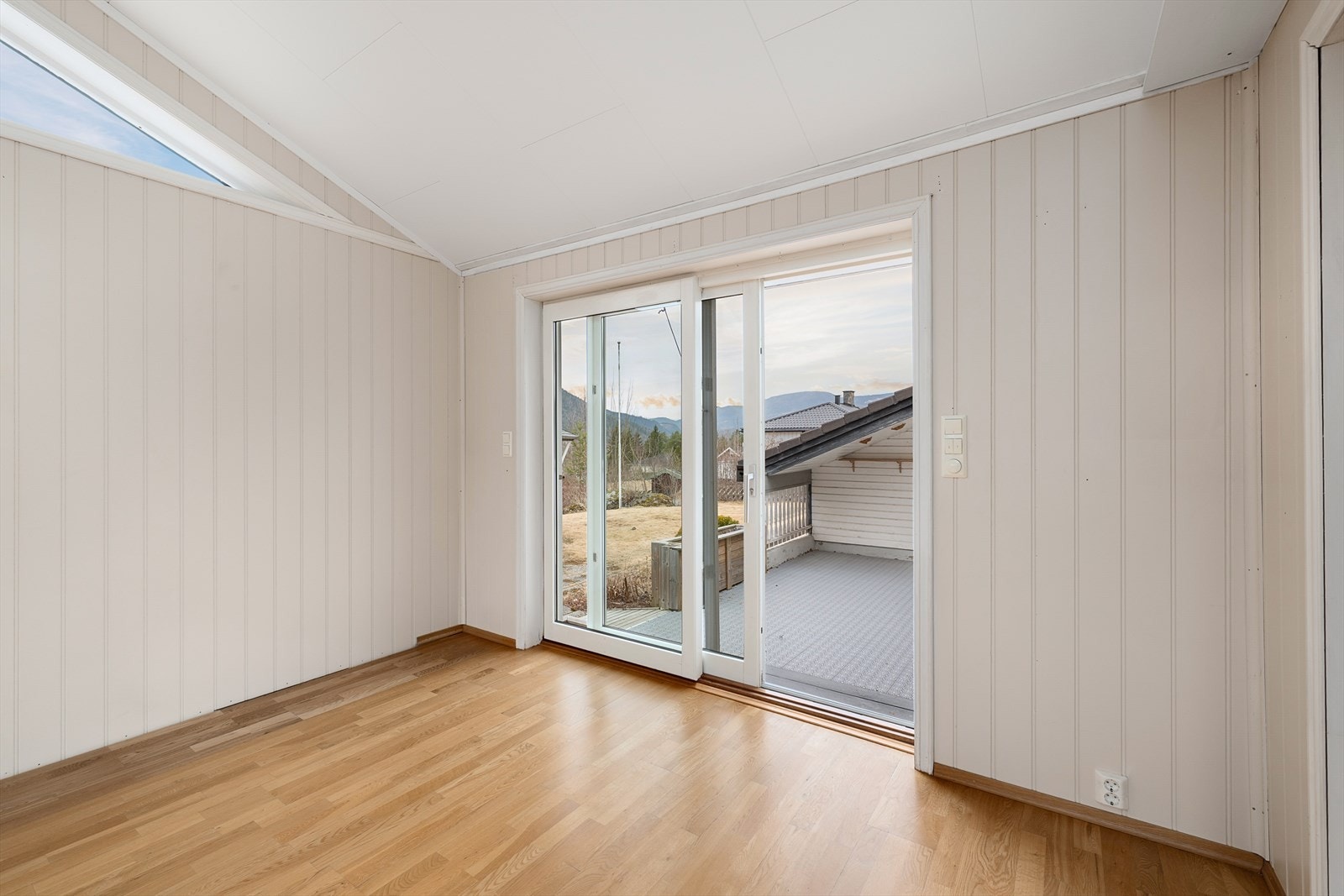 Skyvedør i malt tre gir direkte utgang til en av eiendommens terrasser og hagen. Galleribilde