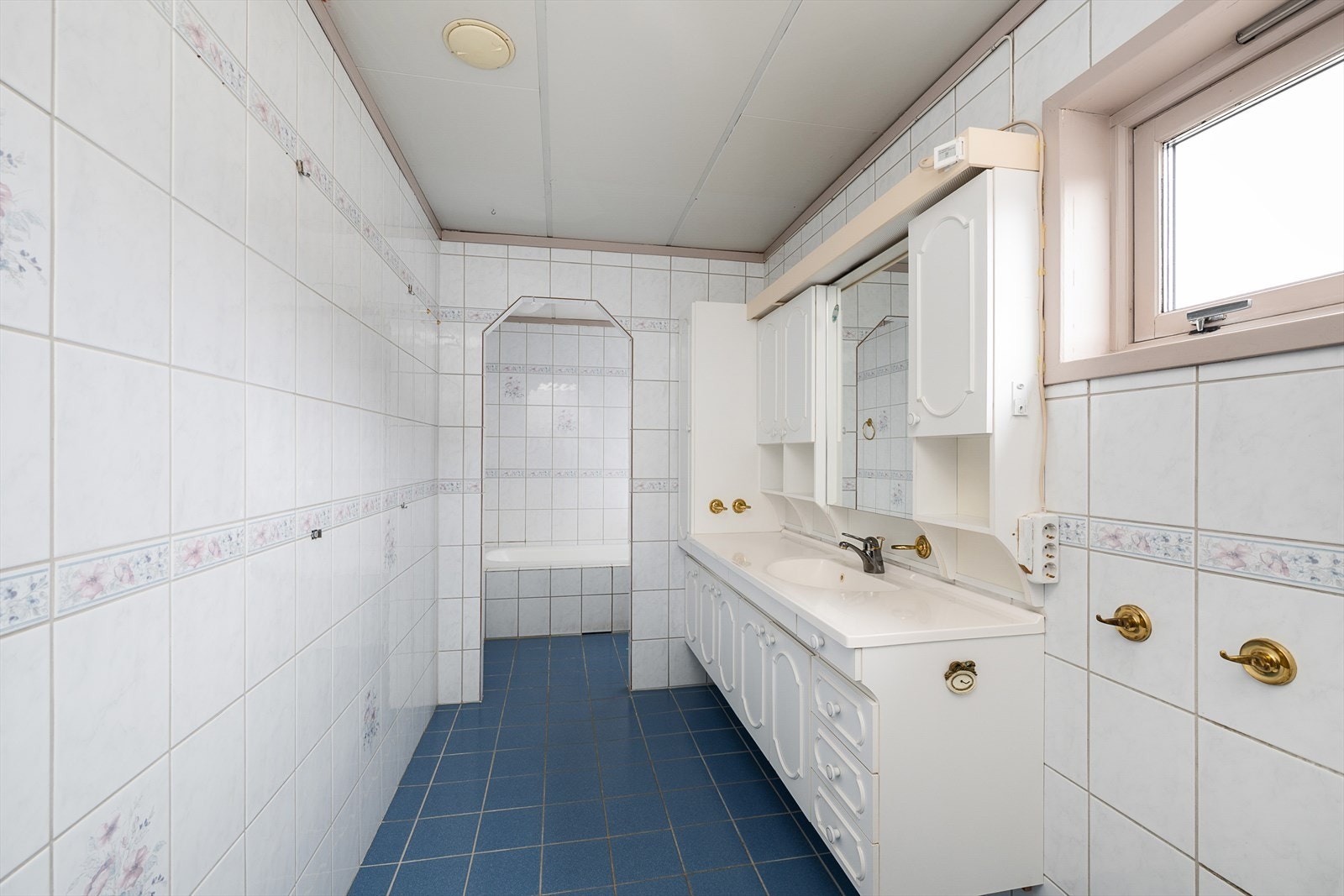 Romslig, flislagt bad med varmekabler i gulvet for økt komfort. Badet ble etablert rundt 1990, og må renoveres. Galleribilde