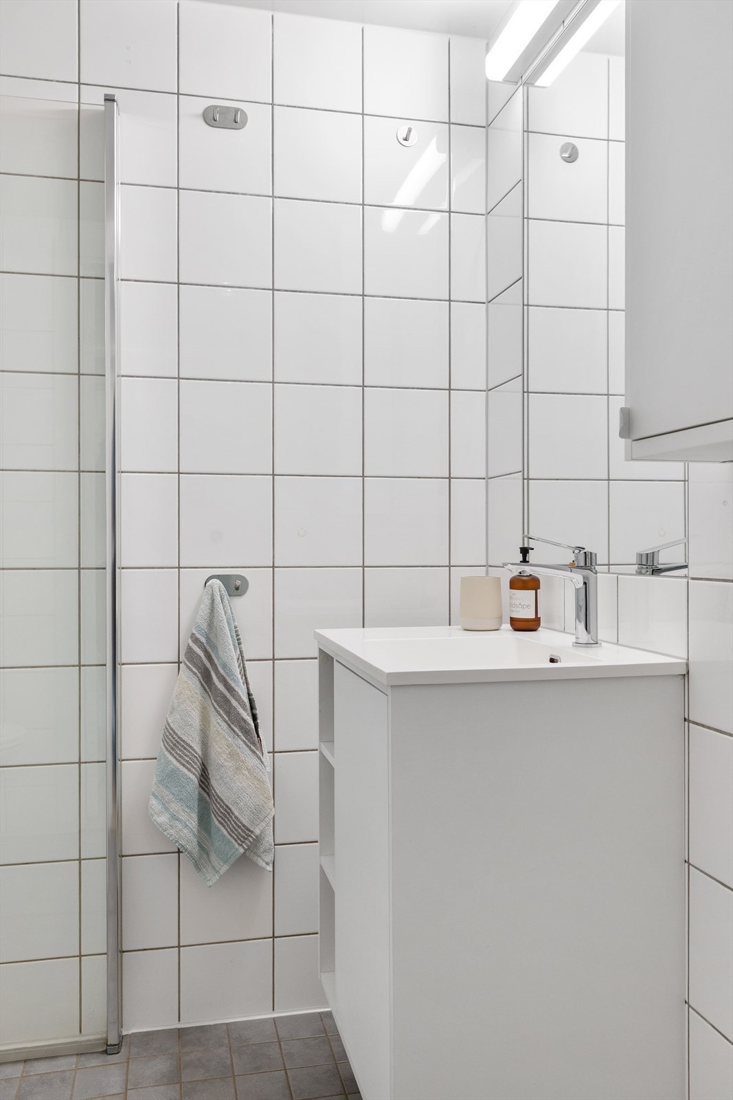 Badet har vegghengt servant med armatur og speil med overlys. Galleribilde