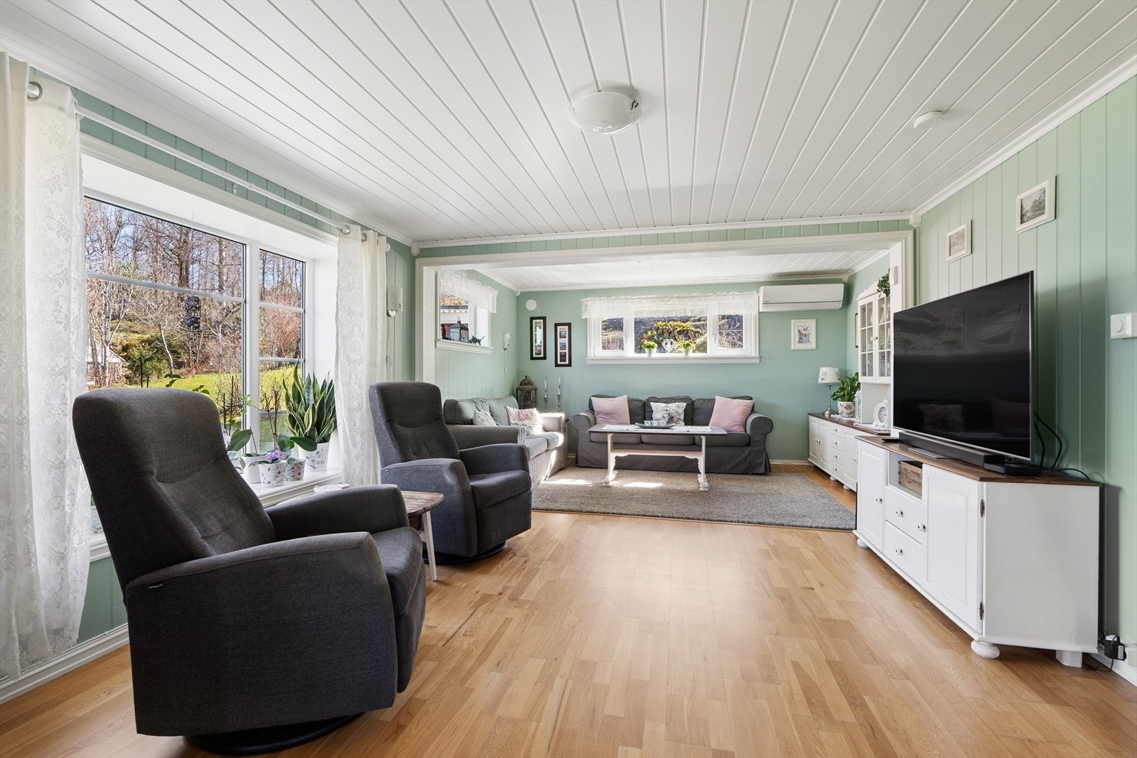 Stuen har plass til flere sittegrupper. En ny vedovn ble montert her i 2021 for ekstra varme og hygge. Galleribilde