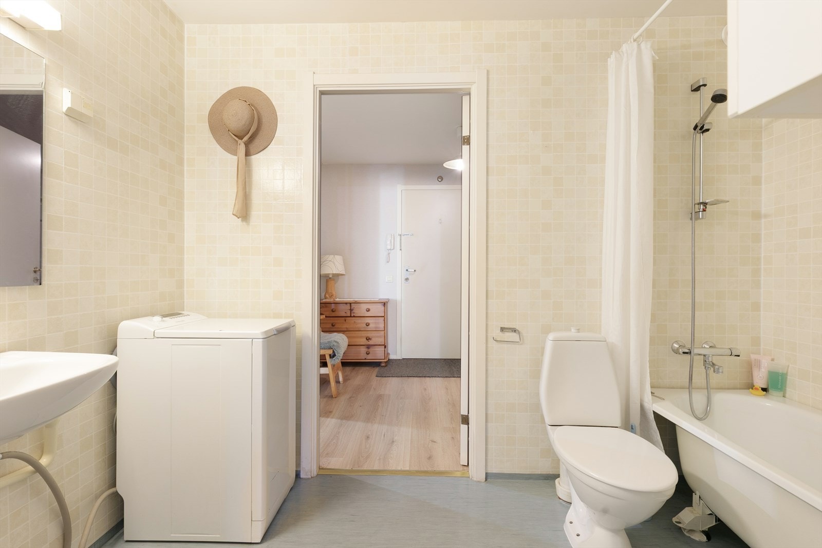 Badet inneholder servant, opplegg for vaskemaskin, gulvmontert klosett og badekar med dusjløsning. Galleribilde