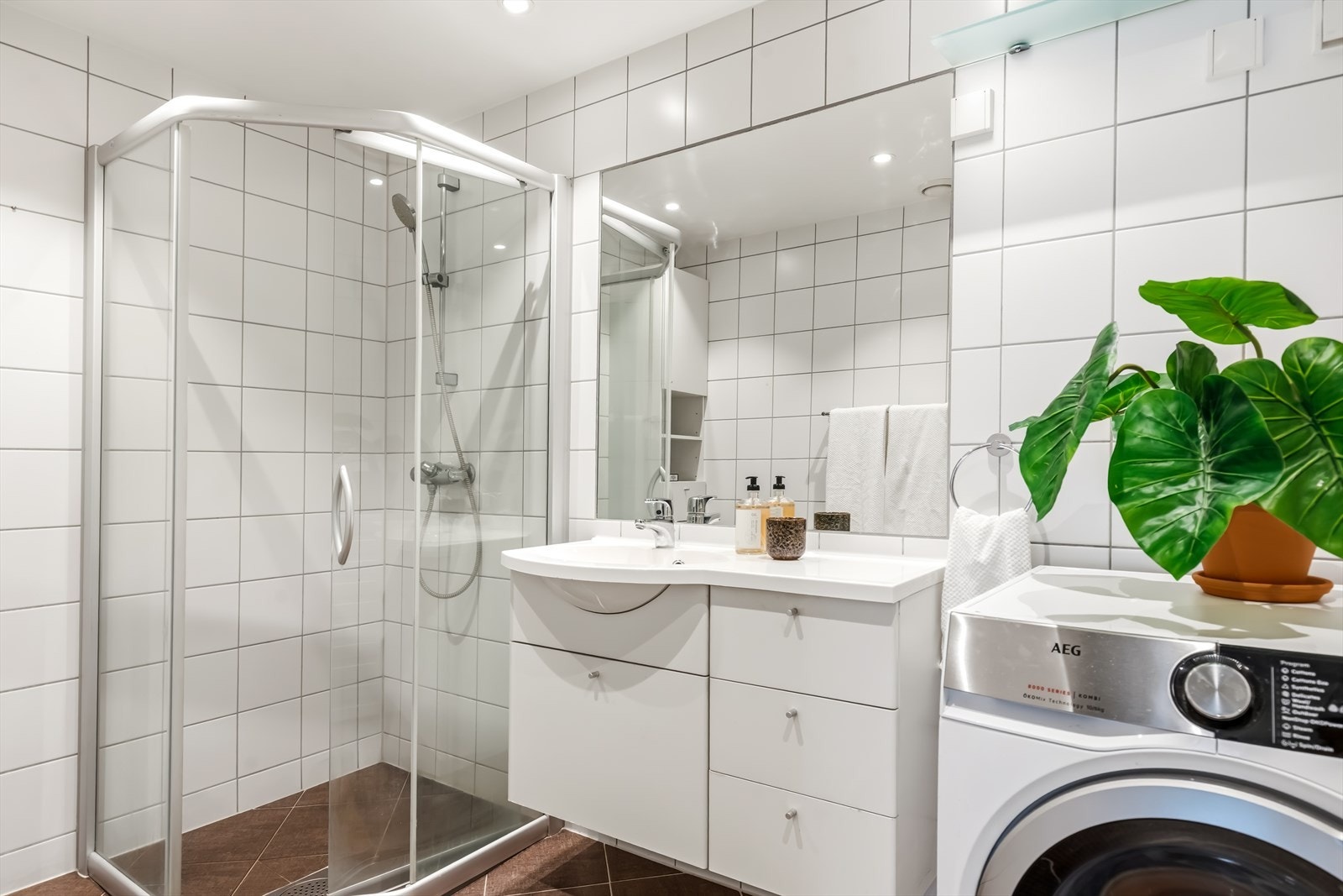 Badet er flislagt og utstyrt med vannbåren gulvvarme, dusjhjørne og opplegg for vaskemaskin. Galleribilde