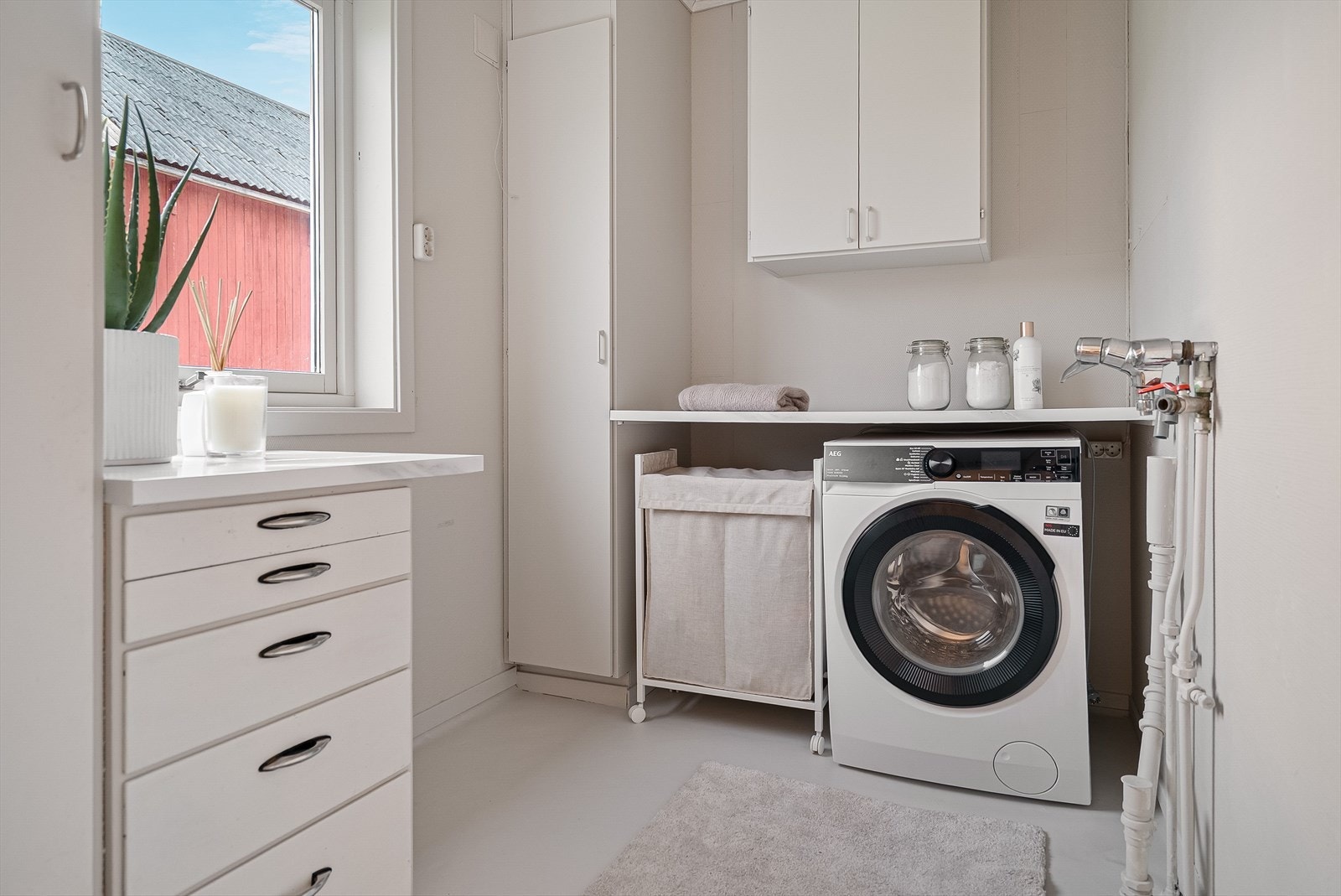 Vegg i vegg ligger et praktisk vaskerom med effektive arbeidsflater og plass til det meste. Galleribilde