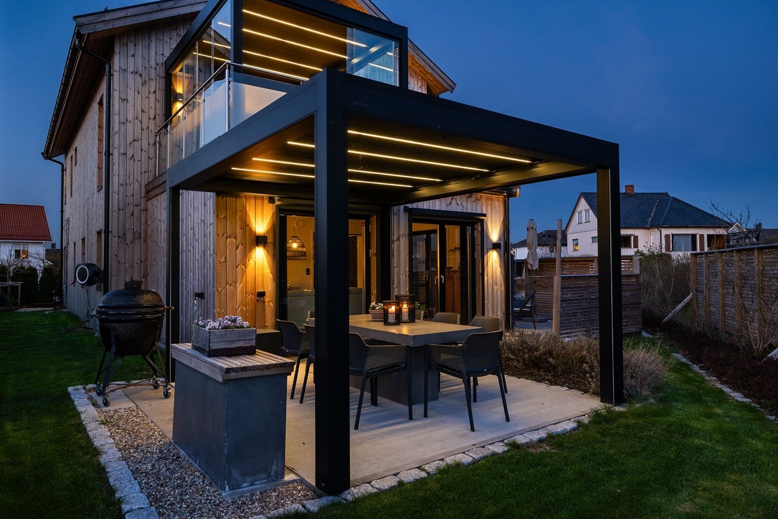 Eiendommen er tilrettelagt for et komfortabelt uteliv med flere soner, inkludert en uteplass med pergola. Galleribilde
