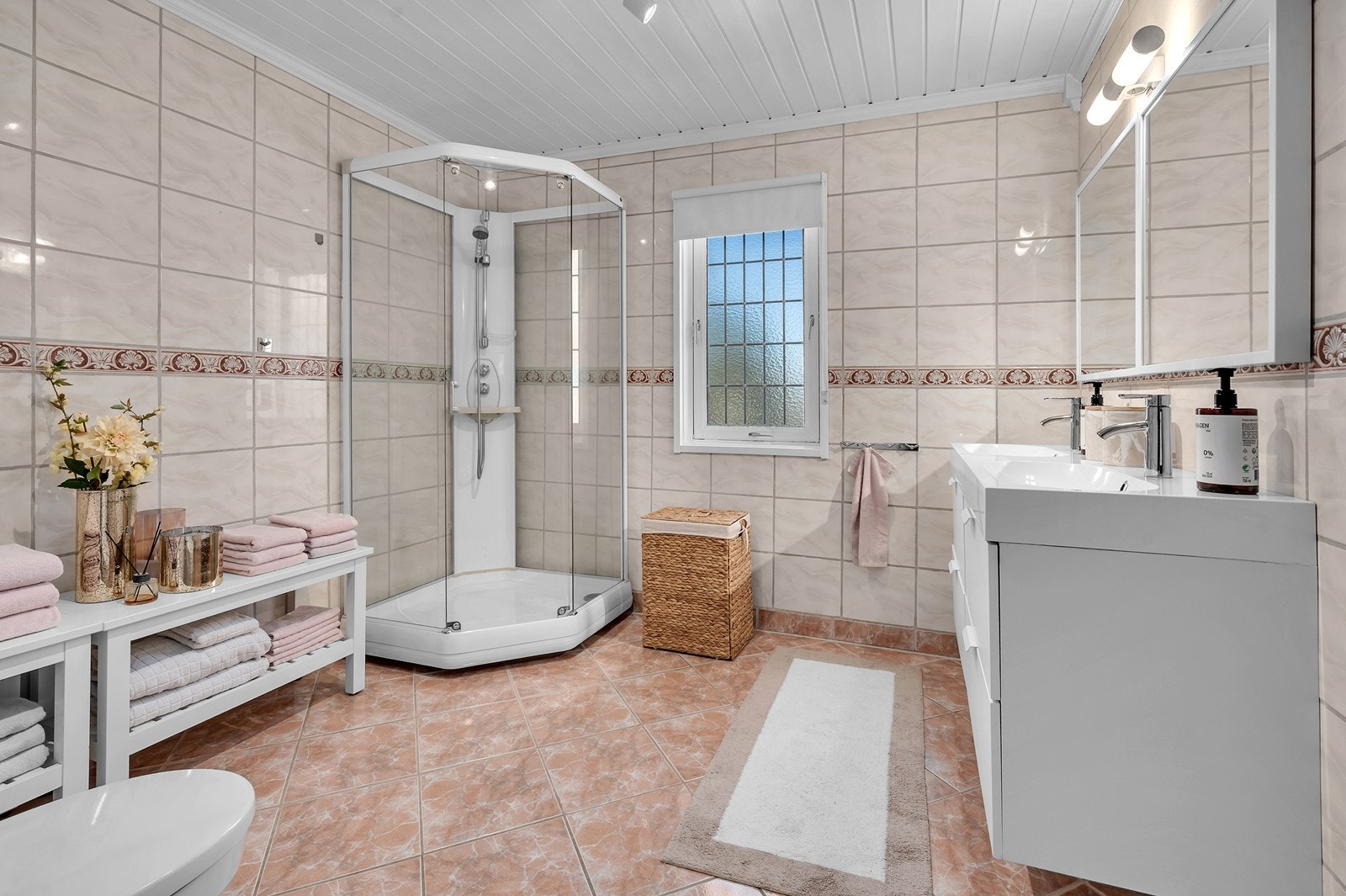 Badet i hovedetasjen har flislagte overflater og varmekabler i gulvet. Badet er utvidet ved at terrasse er innlemmet i rommet. Utvidelsen/endringen er ikke søkt godkjent. Galleribilde