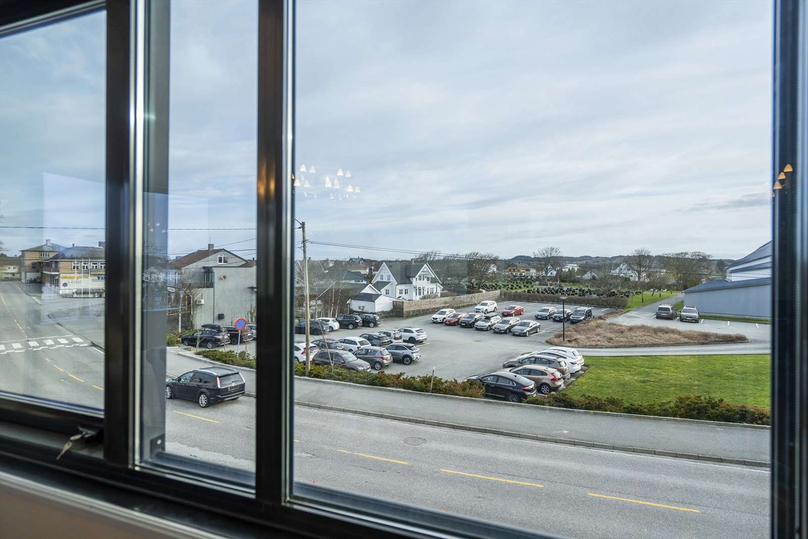 Utsikt over dagligvare, frisør, restaurant og Veavågen kirke. Galleribilde