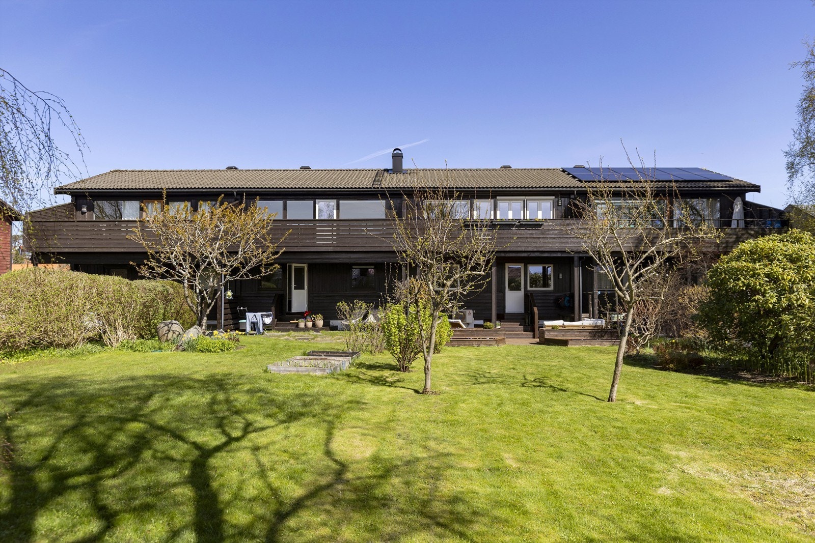 Den store felleshagen er pent opparbeidet med plen og diverse beplantning. Galleribilde