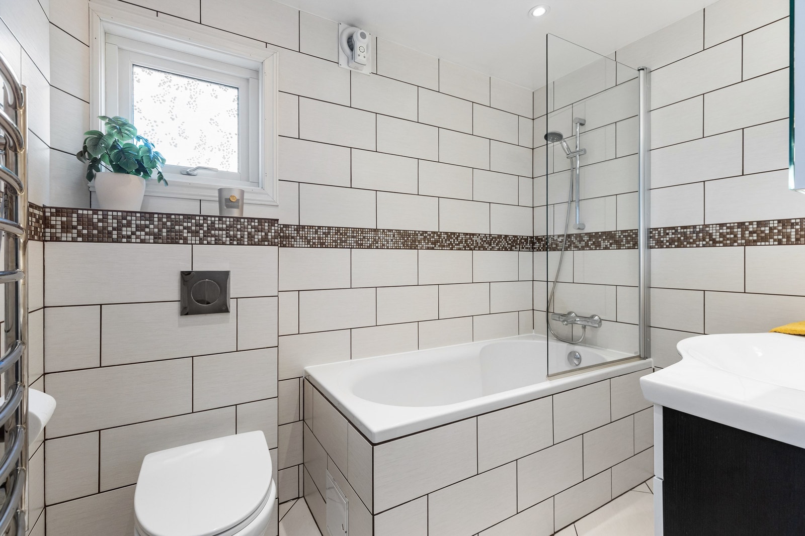 Badet i første etasje er helfliset og utstyrt med badekar, vegghengt toalett og gulvvarme. Galleribilde