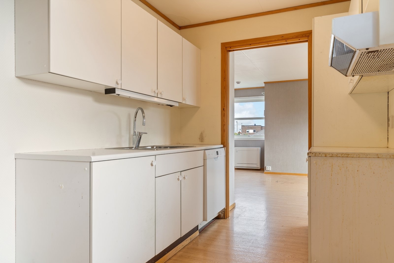 Kjøkkenet har en innredning med glatte fronter og laminatbenkeplate. Rommet er et godt utgangspunkt for modernisering. Galleribilde