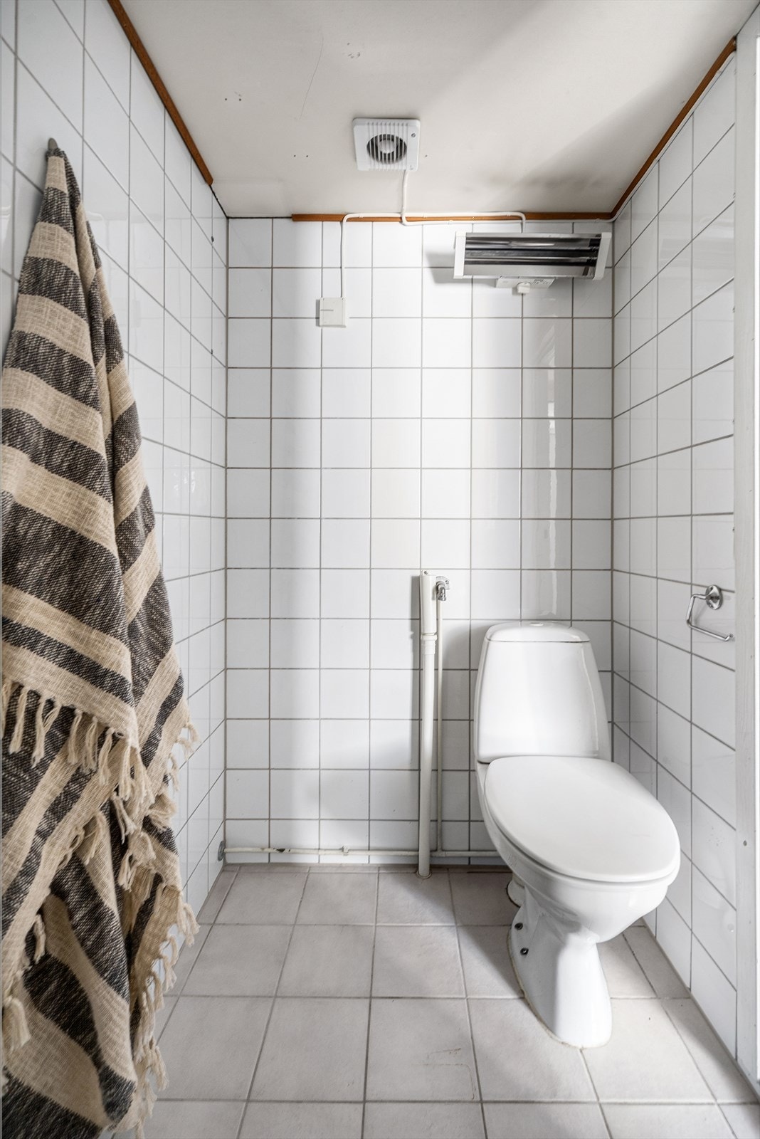 Badet er innredet med frittstående toalett, servant og åpent dusjhjørne. Det er opplegg for vaskemaskin. Galleribilde